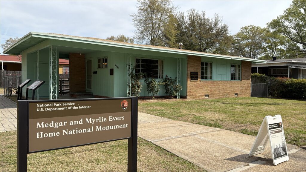 MME - house photo The Evers home, a low green and brick house, with the National Park Service monument sign in front of it